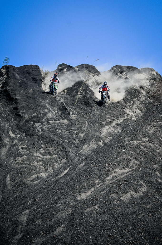 Two Enduro Riders racing downhill in the black lava at Batur volcano in Bali